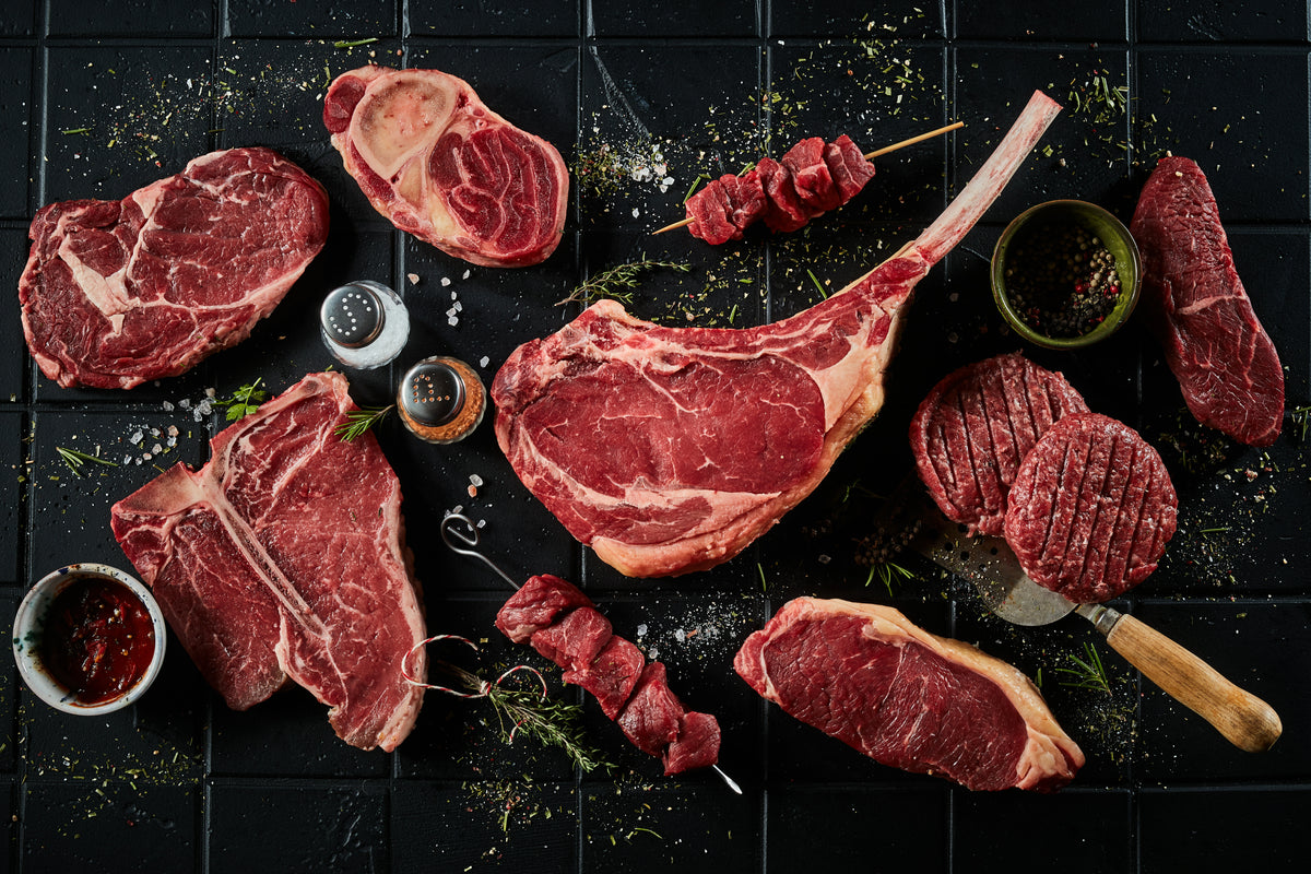 Assorted cuts of raw beef including burgers, steaks and kebabs